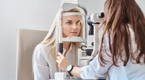 A young woman having her eyes checked by an optometrist