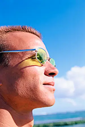 Close up of a man wearing sunglasses looking up at the sky