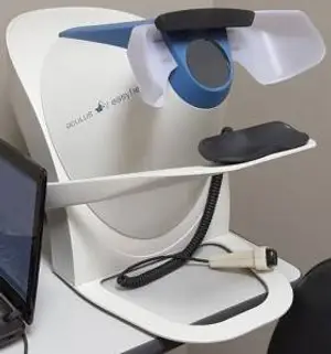 A white and blue medical device with a mouse and laptop in a room