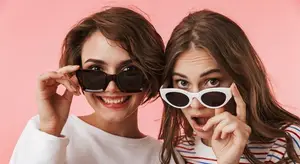 Two women wearing sunglasses and smiling for a photo