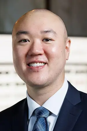 A smiling bald man wearing a suit and tie