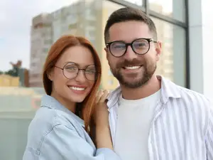 A man and a woman are standing close to each other and posing for a photo with a smiling face