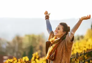 Happy woman in a vineyard with arms outstretched