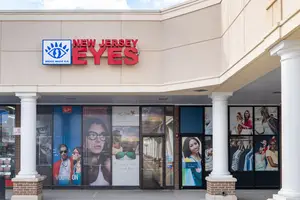 A store with a New Jersey Eyes sign with people in front of it.