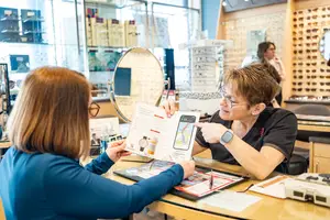 Two women looking at a brochure inside a store