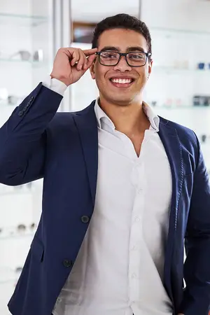 A man adjusting his glasses inside of a store