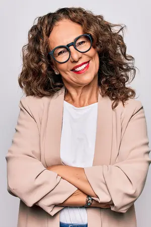 woman in a blazer and glasses with a confident smile