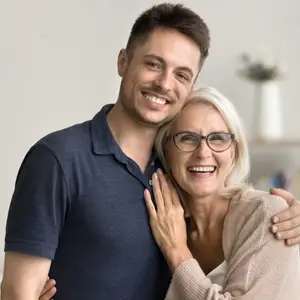A smiling man and woman stand close to each other, possibly posing for a photo.