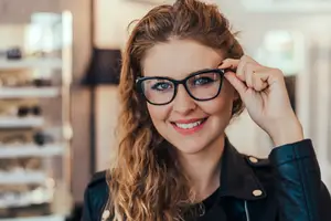 A smiling woman wearing glasses in a shop