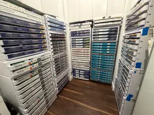 Stacks of colorful boxes with labels like MAX, TOTAL, and MyDay are organized in a neat manner in a room with wooden flooring and white walls.