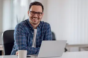 man sitting at laptop wearing eyeglasses