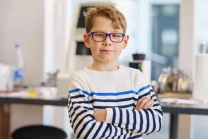 young boy wearing eyeglasses in class