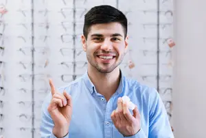 man holding contact lens on finger