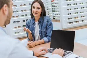 male optician helping female patient