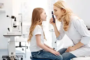 A woman doctor examining a young girl's eye in an eye clinic