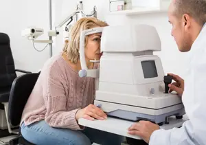 A woman is having her eyes checked by an optometrist in a clinic.
