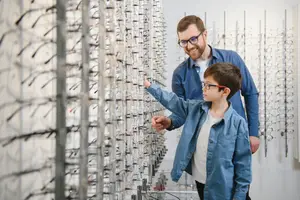 A man and a boy are looking at glasses in a shop.