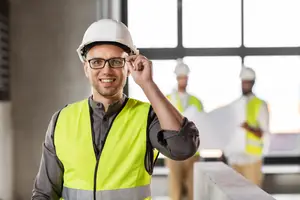 Man in construction safety gear standing at a construction site