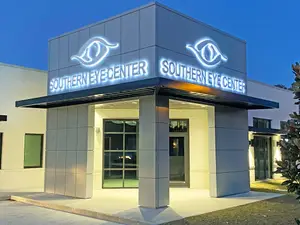 Southern Eye Center with lit-up signage and a tree in front