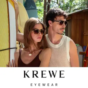 Krewe Eyewear advertisement featuring a man and a woman wearing sunglasses and standing near surfboards in a beach setting