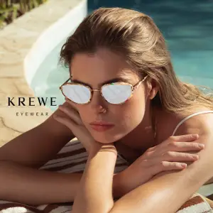 A woman wearing Krewe eyewear sunglasses is posing by a pool.