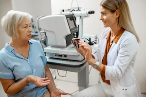 An older woman is consulting with an optometrist in an eye care clinic.