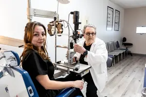 A woman is getting her eyes examined by a doctor in a clinic