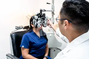 An eye doctor is checking a patient's eyes using a device