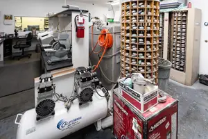 Industrial workspace with equipment, shelves, and storage boxes.