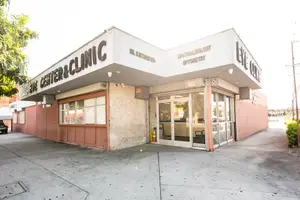 Eye Center and Clinic building on a bright day, with a glass door and a sign reading 'Eye Center and Clinic' above it.