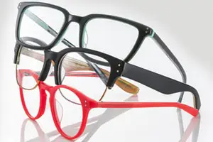 Three pairs of glasses with different colored frames, one in black, one in red, and one in a combination of both, displayed on a white surface.