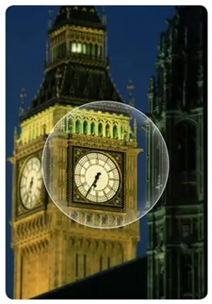 A close-up view of the clock face of the Big Ben tower in London, England, illuminated at night with a glass bubble effect.