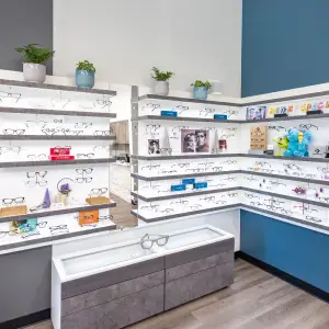 An indoor display of eyeglasses and accessories in a well-lit room with wooden floors and blue walls