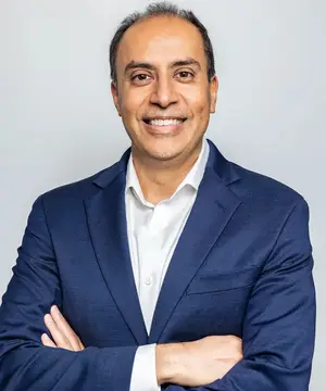 Man in a blue suit smiling for a portrait