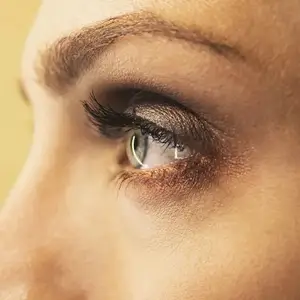 A close up view of a woman's eye with long eyelashes and eyeliner