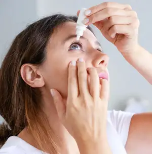 woman applying eye drops