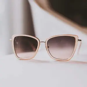 A pair of sunglasses with brown lenses and gold frames