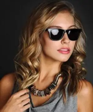 A woman with blonde hair wearing sunglasses and a necklace