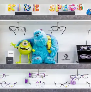 Kid's eyewear store shelf with Monsters Inc. toys and Converse brand products.