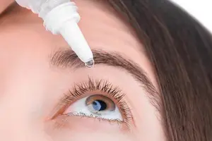 A woman using eye drops for her dry eyes