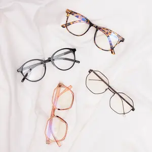 Four pairs of glasses with different frames and lens colors are displayed on a white cloth.