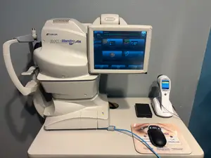A medical device with a screen and mouse is displayed on a desk at Lithonia Family Eyecare in Stonecrest, GA.