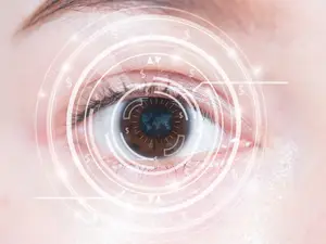 Close up of an eye with a circular symbol with dollar signs in it.