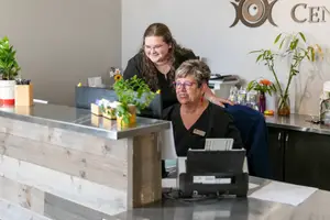 Two women sitting at a desk inside an office.