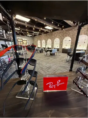 An indoor area that is probably a shop that sells eyeglasses with Ray-Ban eyeglasses displayed on the table
