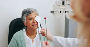 An older woman is having her eye examined by a doctor in a medical clinic