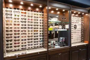 Inside of a shop with different glasses on display in front and a glass display case with other items on the right