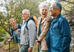 A group of elderly people hiking outdoors on a sunny day