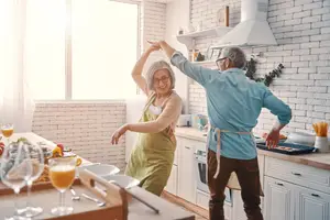 An older couple dancing in a kitchen